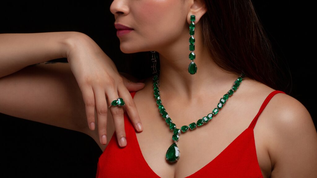 Woman wearing emerald jewelry, red dress.